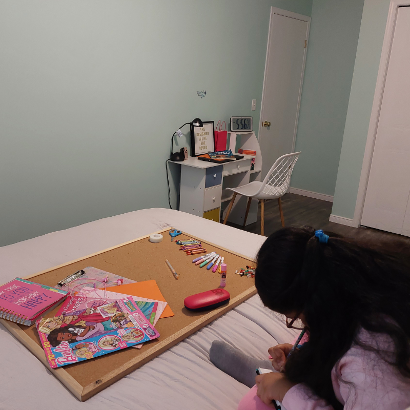 A tween girl journaling before creating her vision board. 5 Steps On How To Make A Vision Board For Tweens