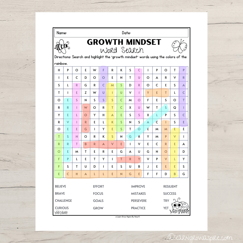 Printable growth mindset word search activity on a desk. The growth mindset words are highlighted in pastel rainbow colors.