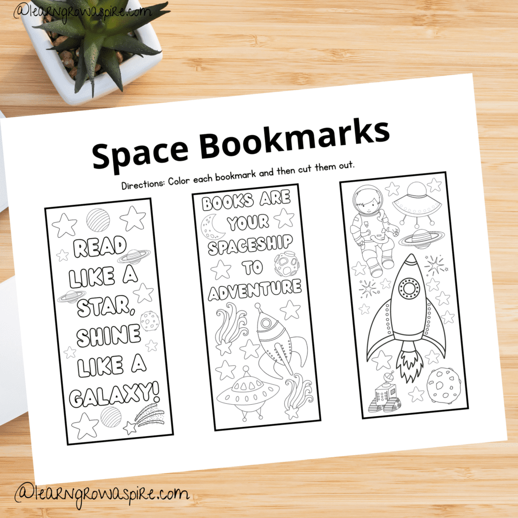 Space bookmarks printable free pdf on a desk. This pdf includes three free space bookmarks for kids printable. 