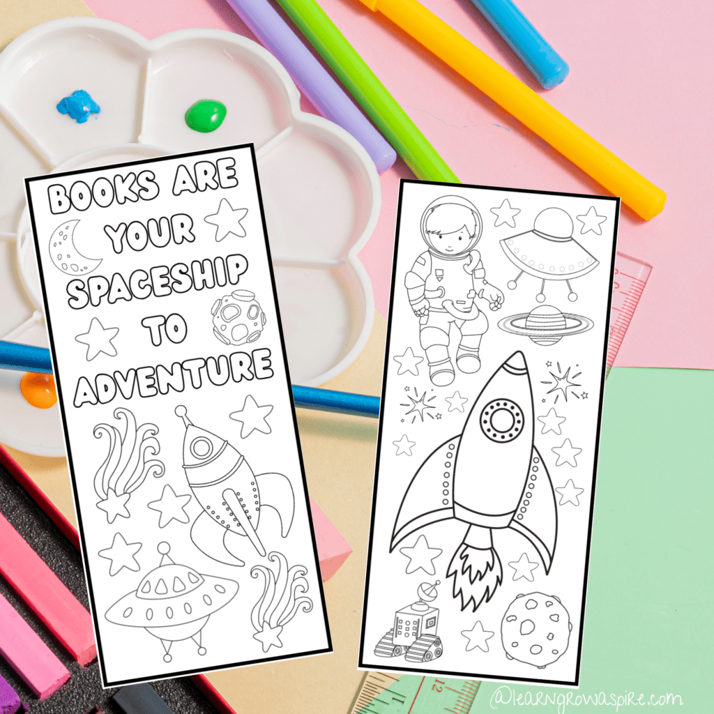 2 space printable bookmarks with space images for kids to color on a colorful pastel counter with stationeries.